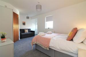 a bedroom with a large bed and a couch at Signature - Great Western View in Whiteinch