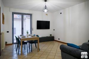 a living room with a table and a tv at VELAHOUSE by Design Studio in Bellano