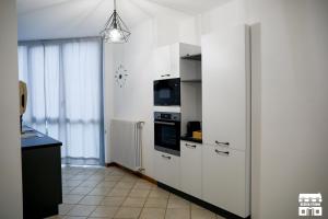 a kitchen with white cabinets and a black counter at VELAHOUSE by Design Studio in Bellano