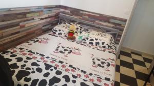 uma cama com um berço de vaca com um brinquedo em maison T3 500m de la plage em Poggio-Mezzana