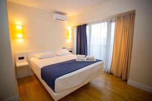 1 dormitorio con cama y ventana grande en ORBI CITY BATUMI AMAZlNG APARTMENT en Batumi