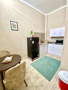 a kitchen with a table and a black refrigerator at Yacoubian Suites in Cairo