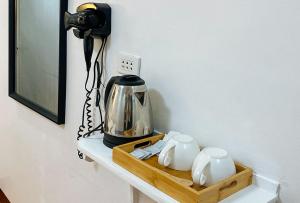una cámara en un estante con una cafetera y tazas en Stay Inn Station 1 Boracay by RedDoorz en Boracay