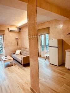 uma sala de estar com um sofá e um frigorífico em Cherry JACUZZI Apartment em Ronda
