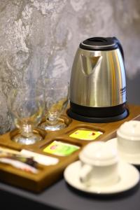 a tea kettle and two glasses on a wooden tray at GRAND DORA HOTEL in Ankara