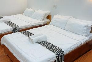 two beds in a room with white and black sheets at Stay Inn Station 1 Boracay by RedDoorz in Boracay