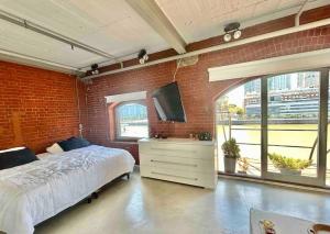 1 dormitorio con cama y pared de ladrillo en Hermoso departamento en Puerto Madero con vista al río en Buenos Aires