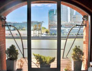 ventana con vistas al río y a los edificios en Hermoso departamento en Puerto Madero con vista al río en Buenos Aires