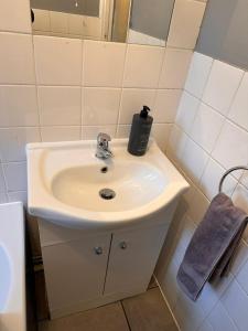 un lavandino in bagno con dispenser di sapone di Letzi - Modern 2 Bedroom Apartment Near Heathrow a Hillingdon