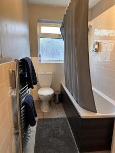 a bathroom with a tub and a toilet and a shower at Letzi - Modern 2 Bedroom Apartment Near Heathrow in Hillingdon