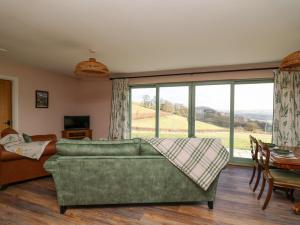 un soggiorno con divano verde e ampia finestra di Dol Blodau a Llandrindod Wells