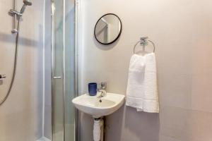 uma casa de banho com um lavatório, um chuveiro e um espelho. em Room 02 - Sandhaven Rooms Double em South Shields