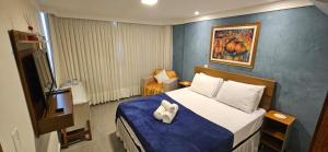 a bedroom with a bed with a blue wall at Kitnet Aconchego dos Nobres in Domingos Martins