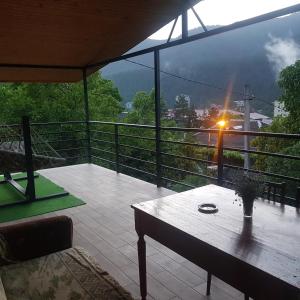 a balcony with a table and a view of a mountain at Guest House Sando in Borjomi