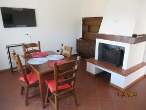 a dining room with a table and a fireplace at Ca' Dei Cedri in Marciaga in Costermano