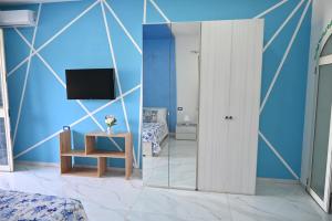 a room with a mirror and a table and a tv at Vesuvius Dream in Boscotrecase