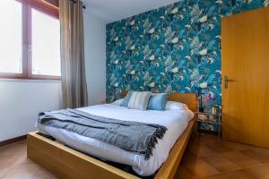 a bedroom with a large bed with a floral wallpaper at Emilia - Elegant and Modern Apartment in Rome
