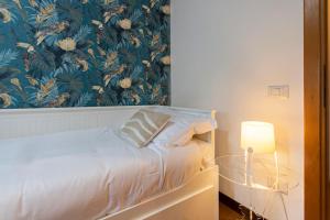 a bedroom with a bed with a lamp and a wall at Emilia - Elegant and Modern Apartment in Rome