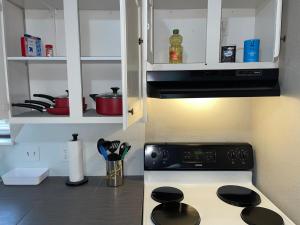 a kitchen with a stove and a white cabinet at Tendayis Paradise - Work Crew Lodging in Abilene