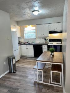 a kitchen with white cabinets and a wooden table at Tendayis Paradise - Work Crew Lodging in Abilene