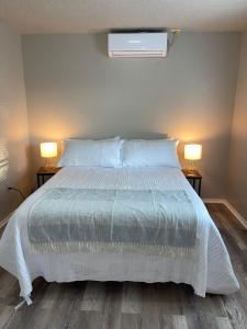 a bedroom with a white bed with two lamps at Tendayis Paradise - Work Crew Lodging in Abilene