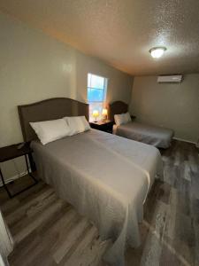 a hotel room with two beds and a window at Tendayis Paradise - Work Crew Lodging in Abilene