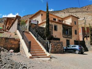 um carro estacionado em frente a um edifício com escadas em Gite chez Ali Agouti Maison Berbère em Idoukaln