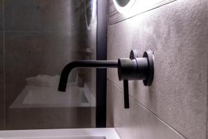 maniglia di una porta nera su un muro in bagno di Alipa Suite with Jacuzzi a Monopoli
