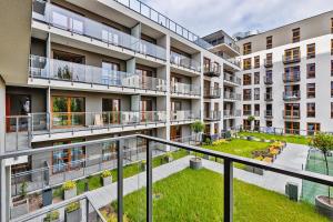 an apartment building with a grassy courtyard at Ilumino Prestige by LookAp - Centrum in Łódź