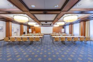 einen Konferenzraum mit Tischen, Stühlen und einem Whiteboard in der Unterkunft Parkhotel 1901 Mannheim in Mannheim