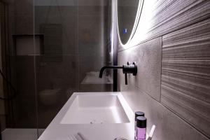 un bagno con un lavandino bianco e una doccia di Alipa Suite with Jacuzzi a Monopoli