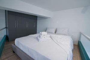 um quarto com uma grande cama branca e um armário preto em Oculus Dafni Loft A em Atenas