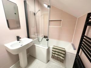 a white bathroom with a sink and a shower at Bank House, Settle, Yorkshire Dales in Settle