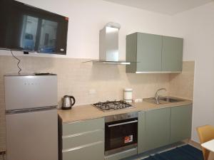a kitchen with a stove and a refrigerator at Da Enza - Appartamento al mare in Grottammare