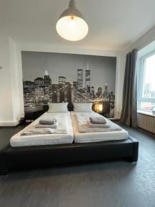 a bedroom with two beds with a city mural on the wall at Schängelrooms in Koblenz