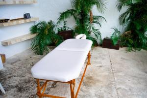 a white chair in a room with plants at Hotel Aldea del Bazar & Spa in Puerto Escondido