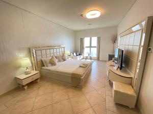 Schlafzimmer mit einem Bett, einem Schreibtisch und einem TV in der Unterkunft Stunning Marina View! Solo Room in Shared Apartment at Luxurious Princess Tower in Dubai