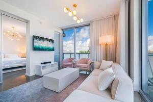 a living room with a white couch and a bed at Luxurious Oceanview 1BR Apt with Resort Amenities in Miami Beach