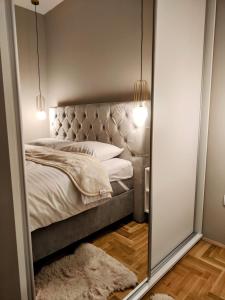 a mirror in a bedroom with a bed at Apartman Samsara in Sarajevo
