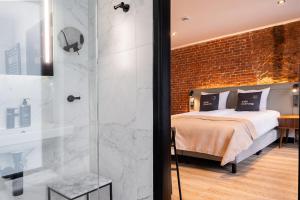 a bedroom with a bed and a glass shower at limehome Amsterdam Leidsekruisstraat in Amsterdam