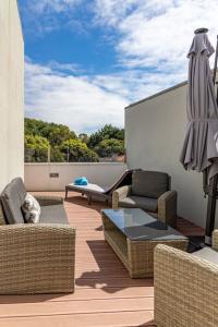 a patio with chairs and an umbrella and a cat sleeping at Mifi Beach Luxury Duplex by MP in Vila Nova de Gaia