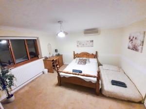 una camera da letto con due letti e una finestra di Old Slade Cottage - Train to London 30mins, Heathrow 15mins away,Free Parking - En-suit rooms a Buckinghamshire