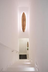 a hallway in a white building with a wooden artifact on the wall at Mifi Beach Luxury Duplex by MP in Vila Nova de Gaia