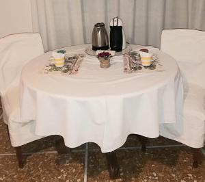 einen weißen Tisch mit zwei Stühlen und eine Teekanne drauf in der Unterkunft Amico Del Sole in Rom