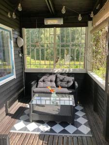 a screened in porch with a couch and a table at Stuga i Norra Kvarnviken in Bengtsfors