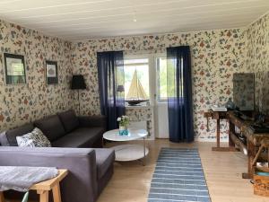 a living room with a couch and a table at Stuga i Norra Kvarnviken in Bengtsfors