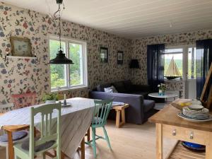 a kitchen and living room with a table and a couch at Stuga i Norra Kvarnviken in Bengtsfors