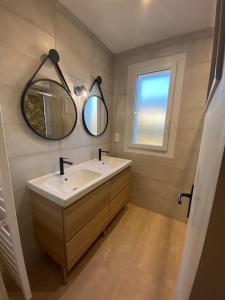 ein Bad mit einem Waschbecken und einem Spiegel in der Unterkunft Chez Tad Kozh Maison familiale in Paimpol