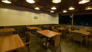 a restaurant with tables and chairs in a room at Dandeli Nature Resort in Dandeli