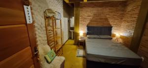 a room with two beds and a brick wall at IbitiAnJo - Suítes in Conceição da Ibitipoca
